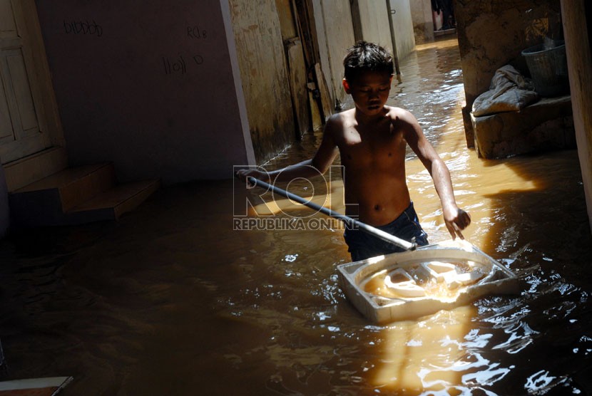  Warga melintasi banjir yang menggenangi kawasan Kampung Melayu Kecil 1, Poncol, Bukit Duri, Jakarta Selatan,Senin (22/10).   (Agung Fatma Putra)