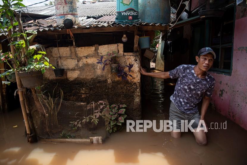 Warga melintasi banjir yang menggenangi permukiman di Pondok Pinang, Kebayoran Lama, Jakarta Selatan disebabkan Kali Pesanggrahan yang meluap. Pemkot Jakbar bakal membangun tanggul di Kali Pesanggrahan pada 2023 mendatang.