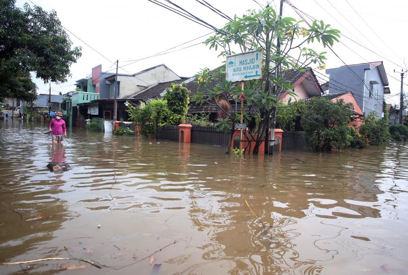 Warga melintasi banjir yang merendam Perumahan Ciledug Indah, Ciledug, Tangerang, Banten, Sabtu (16/7/2022). Banjir setinggi 50cm hingga 100cm yang merendam perumahan itu akibat meluapnya kali angke karena intensitas hujan yang cukup tinggi. Pemkot Tangerang Perbaiki Tanggul Kali Angke yang Jebol