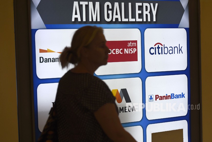 Warga melintasi galeri anjungan tunai mandiri (ATM) di Kebayoran Lama, Jakarta, Senin (5/8/2019). 