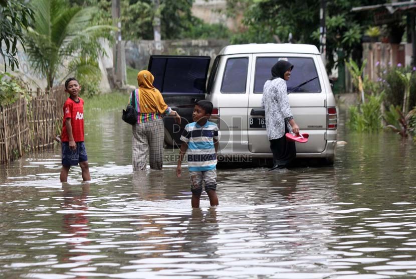  Warga melintasi genangan air saat banjir melanda perumahan Ciledug indah 1, Ciledug, Tangerang, Banten, Kamis (16/1).     (Republika/Yasin Habibi)