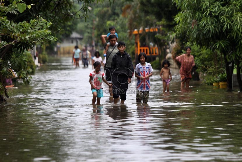  Warga melintasi genangan air saat banjir melanda perumahan Ciledug indah 1, Ciledug, Tangerang, Banten, Kamis (16/1).     (Republika/Yasin Habibi)