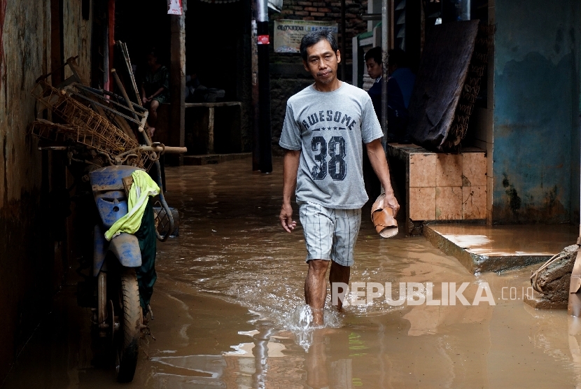 Warga melintasi genangan ketika banjir menggenangi kawasan permukiman di Jakarta Timur, pekan lalu. (ilustrasi)
