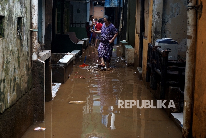 Warga melintasi genangan banjir di Jakarta Timur. (Ilustrasi)