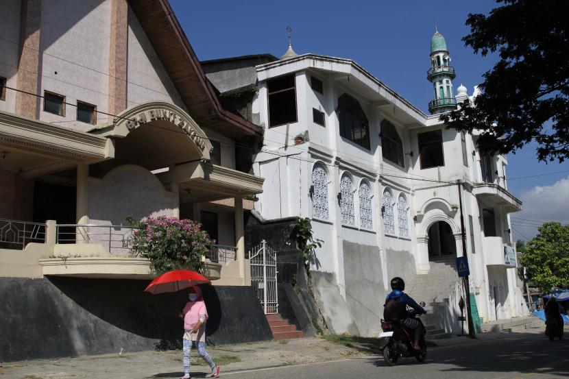 Warga melintasi Gereja Pantekosta Bukit Zaitun (kiri) dan Masjid Dakwah Wanita (kanan) di Kendari, Sulawesi Tenggara (Ilustrasi). Pendirian rumah ibadah harus memenuhi sejumlah syarat dalam SKB 2 Men 