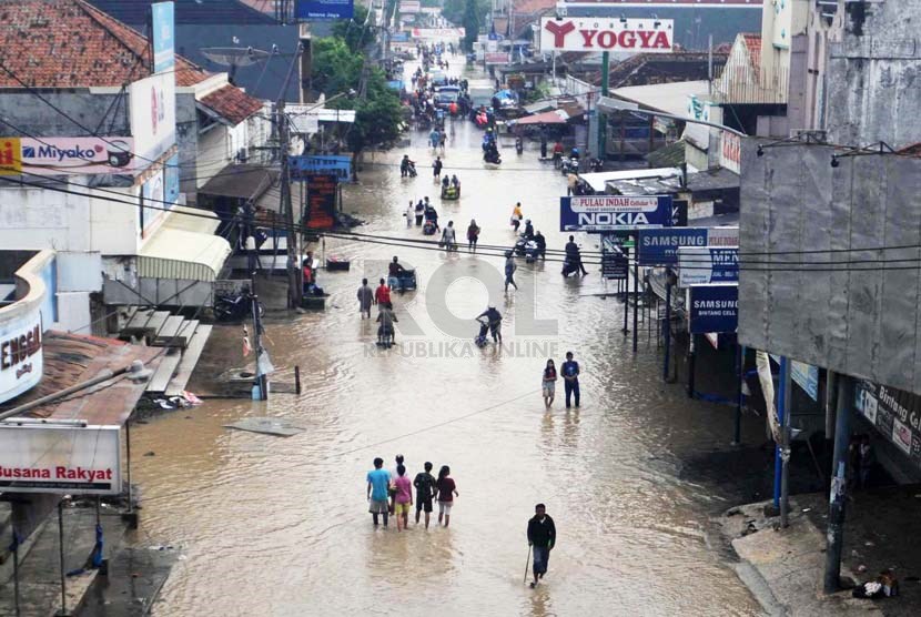 Warga melintasi jalan yang terkena banjir di kawasan Pantura, Pamanukan, Subang, Jabar, Rabu (22/1). 
