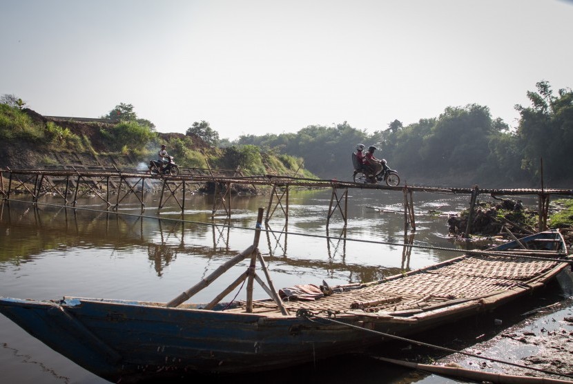 Warga melintasi jembatan bambu di atas Sungai Bengawan Solo yang menghubungkan Desa Mojolaban, Sukoharjo dengan Kampung Sewu di Solo, Jawa Tengah, Rabu (19/6/2019).