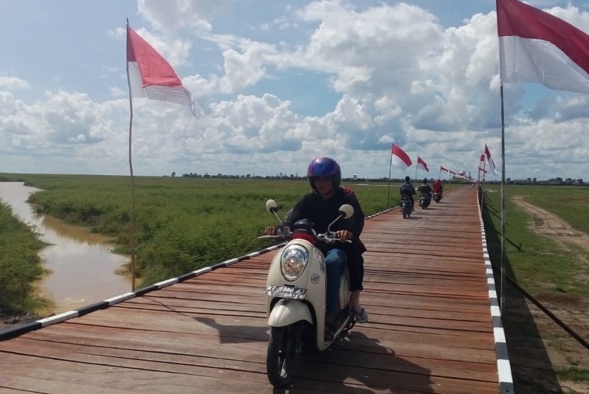 Warga melintasi jembatan penghubung Desa Sebemban dan Desa Melintang di Kecamatan Muara Wis, Kabupaten Kutai Kartanegara, Provinsi Kalimantan Timur pada Selasa (13/11). Jembatan dibangun lewat program TMMD. 