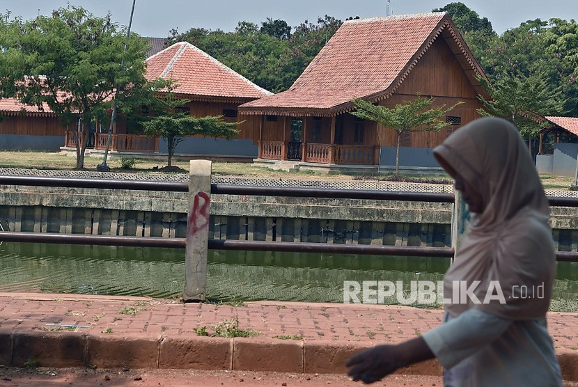 Warga melintasi kawasan replika perkampungan tempo dulu di Zona C Perkampungan Budaya Betawi Setu Babakan, di Srengseng Sawah, Jagakarsa, Jakarta Selatan, Kamis (8/8/2019). 