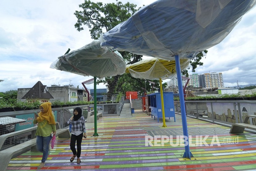 Warga melintasi kios-kios warna-warni sudah tersedia di Skywalk Cihampelas, Kota Bandung, Selasa (31/1). 