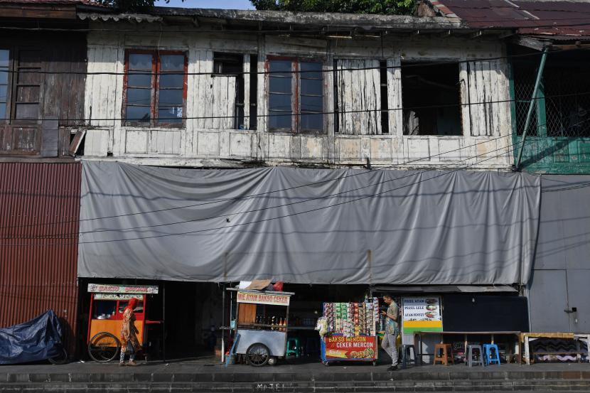 Warga melintasi tempat pedagang kaki lima (PKL) di salah satu sudut kawasan Kota Tua, Jakarta, Senin (1/8/2022). Pemkot Jakbar menggratiskan PKL Kota Tua untuk dua bulan berdagang di Gedung Kemenkeu.