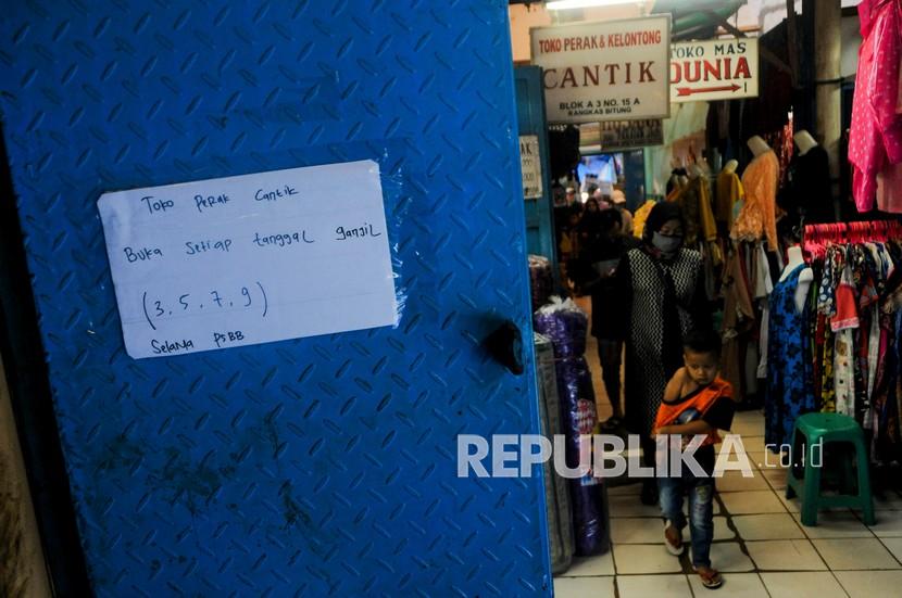 Warga melintasi toko yang tutup di Pasar Rangkasbitung di Lebak, Banten saat PSBB. Ilustrasi