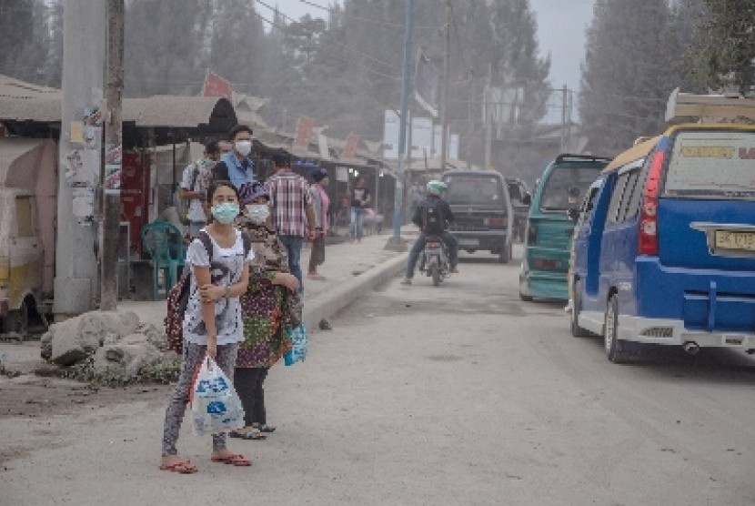 Warga memakai masker untuk mengantisipasi terhirup debu vulkanik erupsi Gunung Sinabung, di Brastagi, Karo, Sumatra Utara.