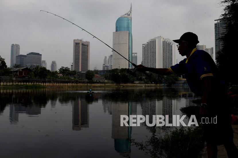 Warga memancing ikan di Waduk Kebon Melati, Tanah Abang, Jakarta Pusat.