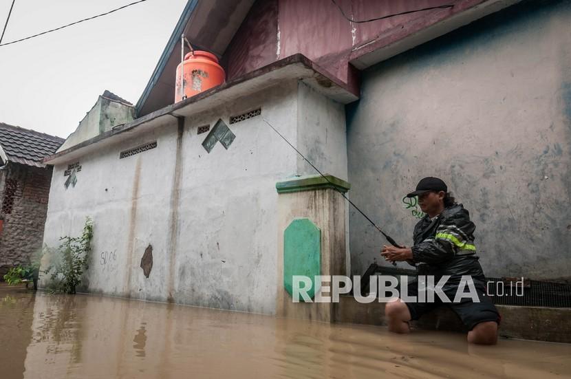 Warga memancing ikan saat banjir di Rangkasbitung, Kabupaten Lebak, Provinsi Banten, Selasa (14/9/2021). 
