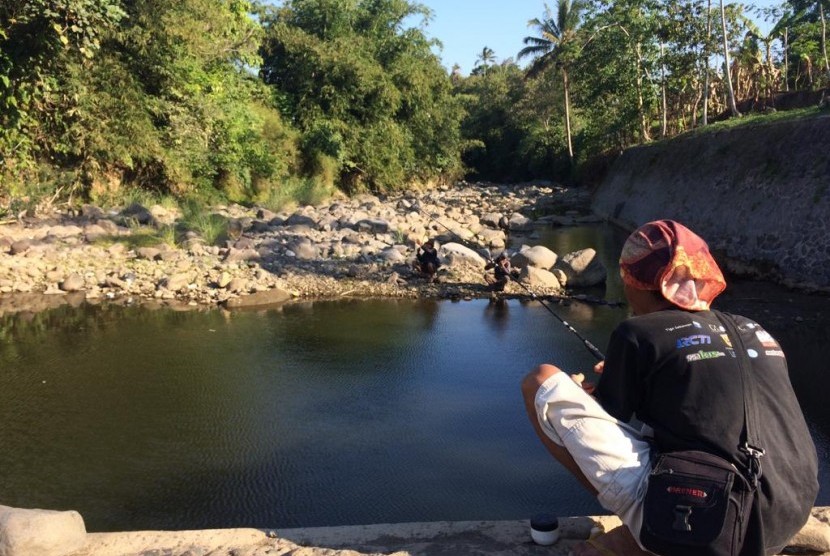  Warga memanfaatkan Bendungan Ciloseh di Kampung Sindanggalih, Kecamatan Sukagalih, Kabupaten Tasikmalaya, yang mengering untuk memancing, Rabu (10/7). Air di Sungai Ciloseh itu sudah mengering sejak sekitar dua bulan silam. 