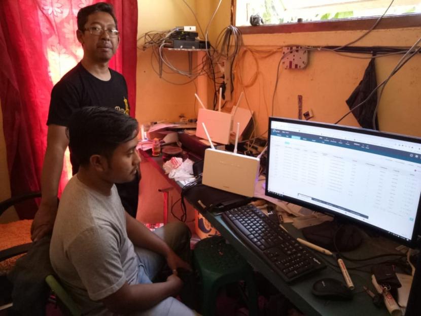 Warga memanfaatkan jaringan internet yang disediakan salah seorang  Badan Usaha Milik Kampun Kampung Cilimushideung, Desa Mekarsari, Kecamatan Cibatu, Kabupaten Garut.