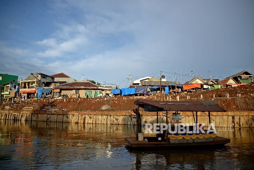  Warga memanfaatkan perahu ertan untuk menyebrang Kali Cliwung di Kelurahan Bukit Duri, Jakarta, Senin (9/1)