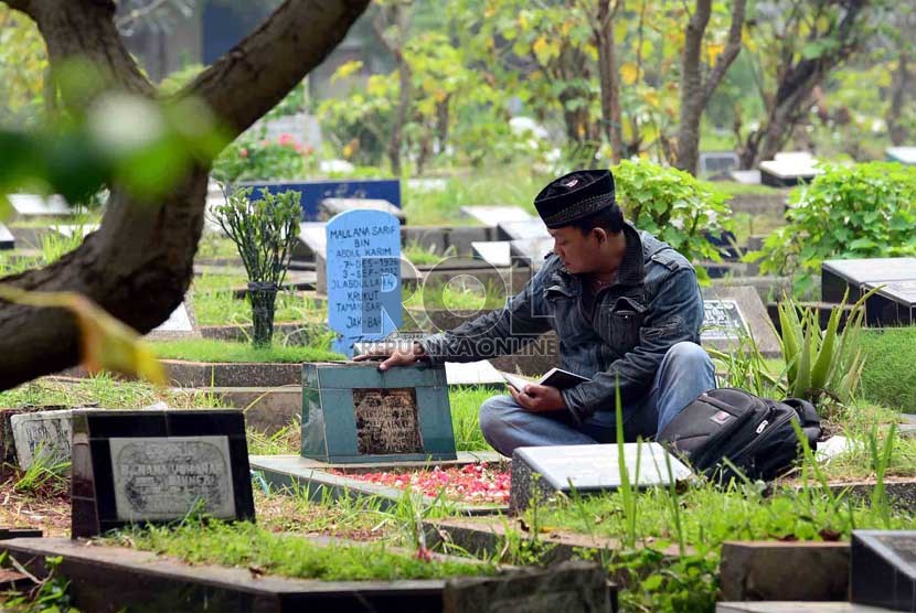  Warga memanjatkan doa ketika berziarah ke makam salah satu keluarganya di TPU Karet, Jakarta,Selasa (2/7).  (Republika/Agung Supriyanto)