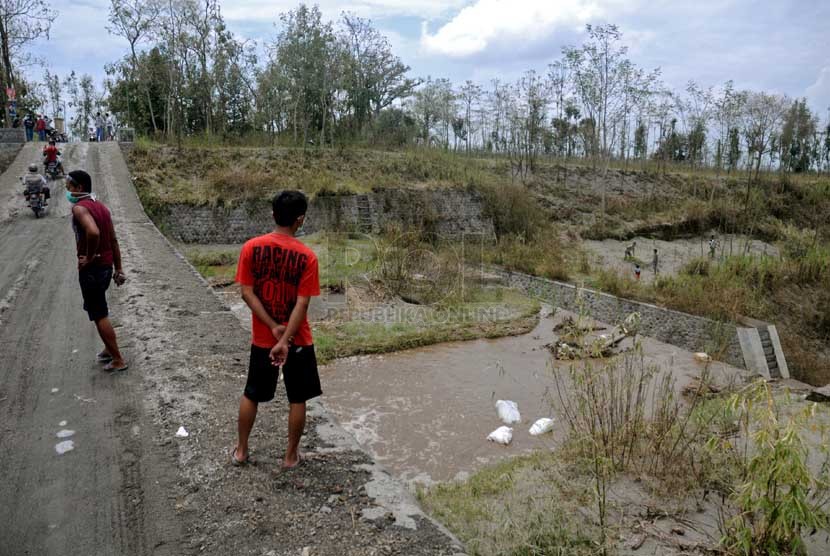  Warga memantau aliran lahar dingin Gunung Kelud yang melintasi Kecamatan Puncu, Kediri, Jawa Timur, Selasa (18/2). (Republika/Adhi Wicaksono)