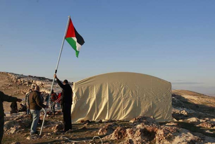 Warga memasang bendera Palestina dekat kota Jerusalem.