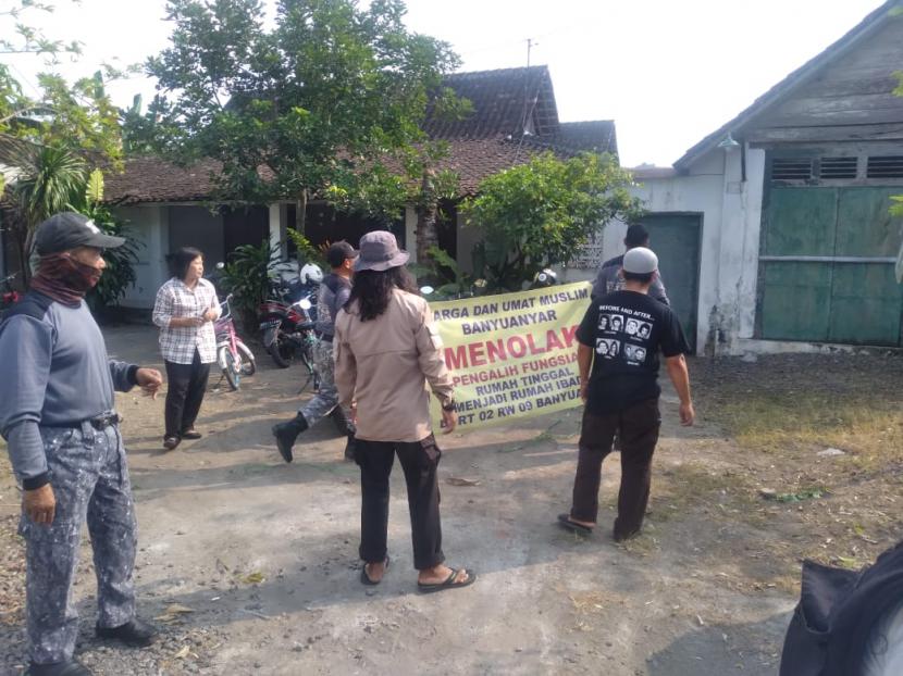 warga memasang spanduk penolakan rumah kosong yang digunakan untuk peribadatan namun tak berizin, Senin (19/6/2023).