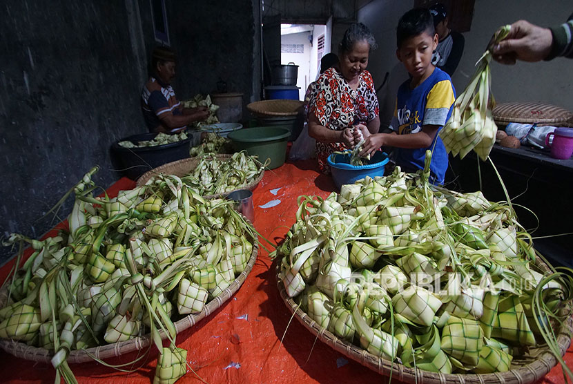 Warga memasukan beras ke dalam cangkang ketupat di Desa Yosonegoro, Kabupaten Gorontalo, Gorontalo.