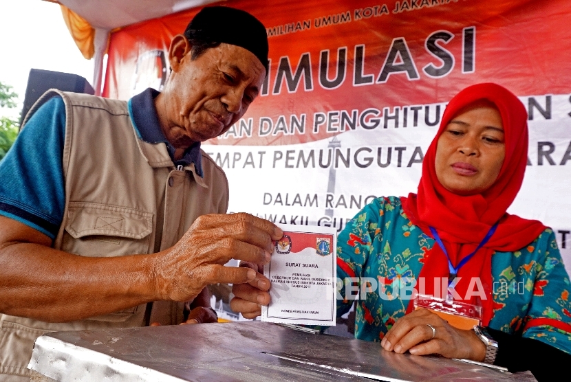 Warga memasukan surat suara kedalam kotak saat mengikuti simulasi pilkada DKI Jakarta di Kantor Kecamatan Jatinegara, Jakarta,Kamis (2/2).