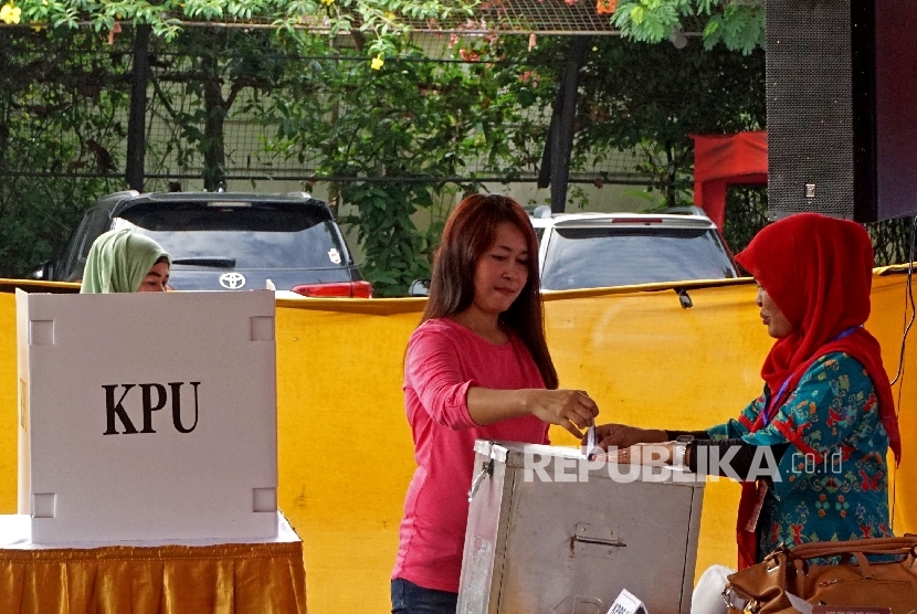 Warga memasukan surat suara kedalam kotak saat mengikuti simulasi pilkada DKI Jakarta di Kantor Kecamatan Jatinegara, Jakarta,Kamis (2/2)