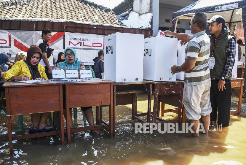 Warga mencoblos di TPS yang mengalami banjir (ilustrasi). BMKG mengimbau penyelenggara pemilu mewaspadai potensi terjadinya cuaca ekstrem di Jawa Tengah.