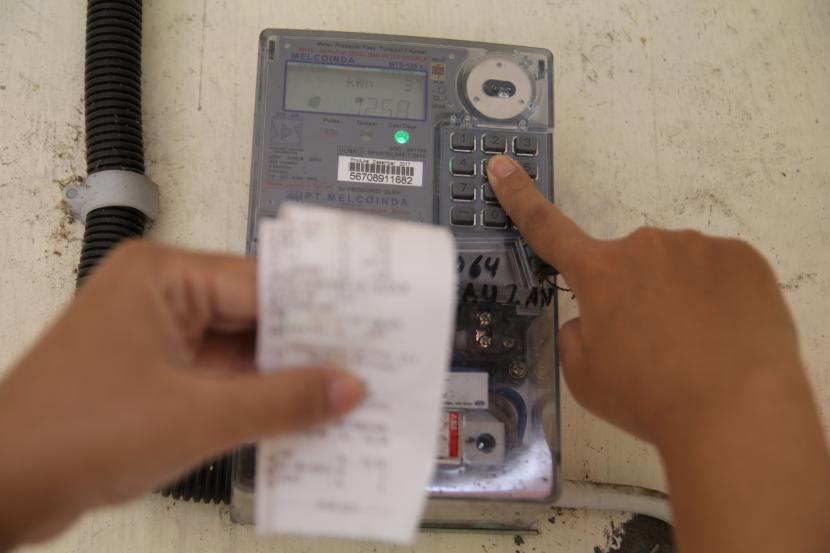Warga memasukkan pulsa token listrik di rumahnya di Kota Kediri, Jawa Timur, Ahad (5/4/2020). Pemerintah memberikan keringanan bagi masyarakat miskin pelanggan listrik PLN selama tiga bulan guna menekan dampak COVID-19 yakni dengan menggratiskan pelanggan listrik 450 VA dan memberikan diskon 50 persen kepada pelanggan listrik 900 VA bersubsidi. 