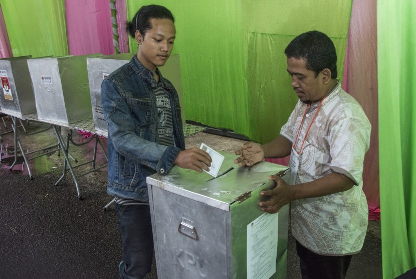 Warga memasukkan surat suara ke dalam kotak suara saat pemilihan ulang Pilkada DKI Jakarta di TPS 01 Utan Panjang, Kemayoran, Jakarta, Minggu (19/2). 