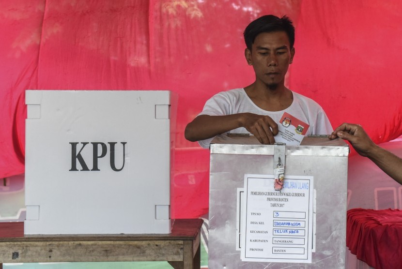 Warga memasukkan surat suara ke dalam kotak suara usai mencoblos pada pemilihan ulang Pilkada Banten di TPS 3 Babakan Asem, Teluk Naga, Tangerang, Banten, Minggu (19/2).
