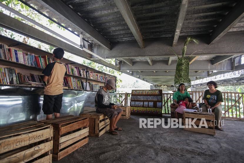 Warga membaca buku di Jembatan Edukasi, kolong jembatan Siluk, Imogiri, Bantul, DI Yogyakarta. 