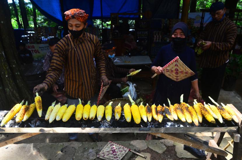 Warga membakar jagung saat Festival 10.000 Jagung Bakar di Desa Kajar, Kudus, Jawa Tengah, Sabtu (18/12/2021). Festival membakar jagung sebanyak 10.000 buah kemudian dibagikan warga secara gratis itu untuk memperkenalkan kuliner berbahan jagung sekaligus mengangkat perekonomian petani jagung.
