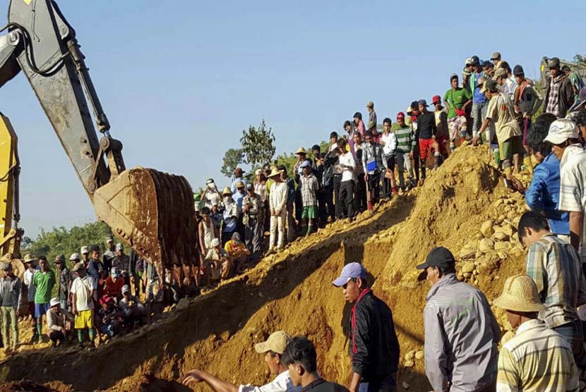 Warga membantu mencari korban longsor di area penambangan giok Hpa Kant jade mining, Kachin State, utara Myanmar, Ahad (22/11). 