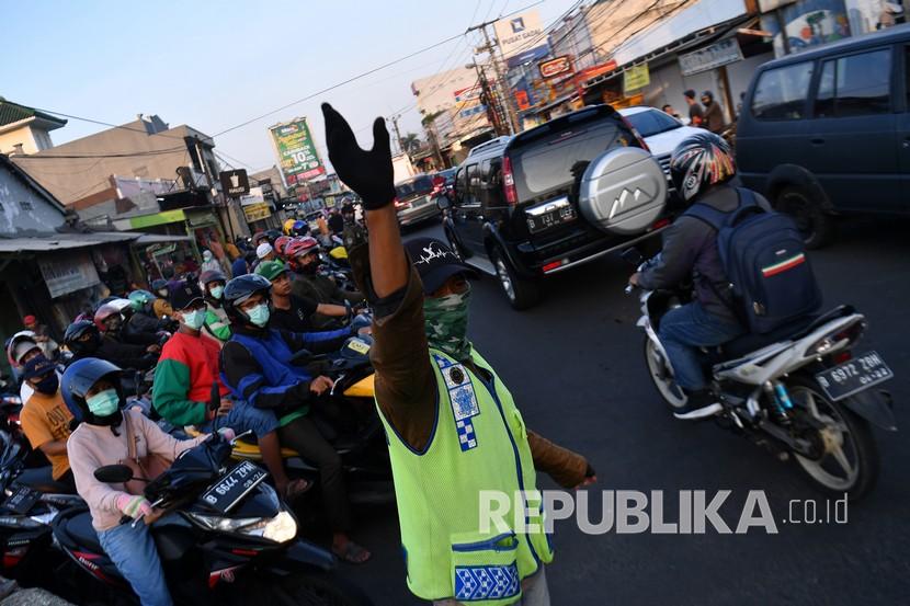Warga membantu mengatur lalu lintas kendaraan di Jalan Raya Sawangan, Depok, Jawa Barat. Pemkot Depok menagih janji BPTJ yang berjanji memperlebar Jalan Raya Sawangan.