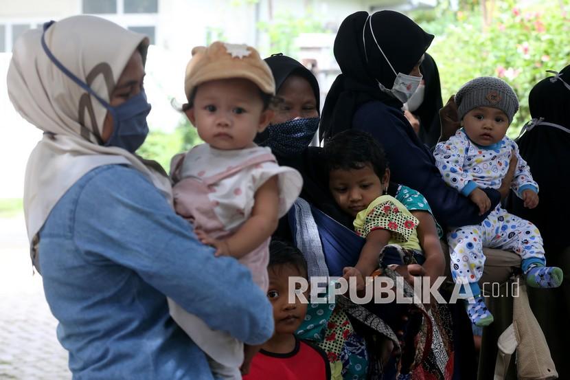 Warga membawa balita untuk mendapatkan imunisasi di Posyandu Banda Aceh, Aceh, Kamis (8/7/2021).
