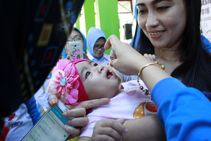 Warga membawa bayinya untuk diberikan vaksin saat pencanangan Pekan Imunisasi Nasional (PIN) Polio di Puskesmas kayu merah, Kabupaten Gorontalo, Selasa (8/3).