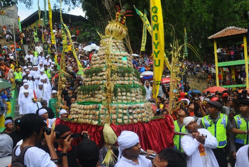 Warga membawa gunungan apem yang dikirab dari Masjid Besar Jatinom untuk disebar saat tradisi sebar apem Ya Qawiyyu di Jatinom, Klaten, Jawa Tengah, Jumat (18/11). 