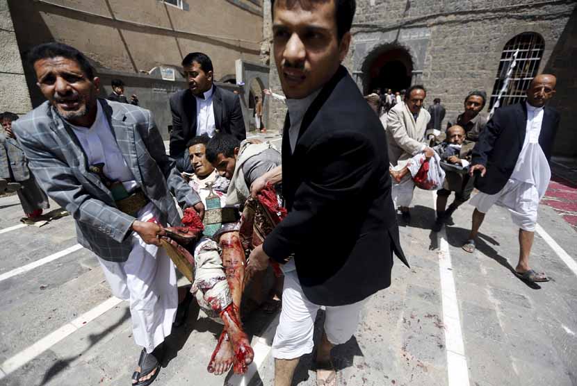 Warga membawa korban bom bunuh diri di sebuah masjid di Sanaa, Yaman, Jumat (20/3). 