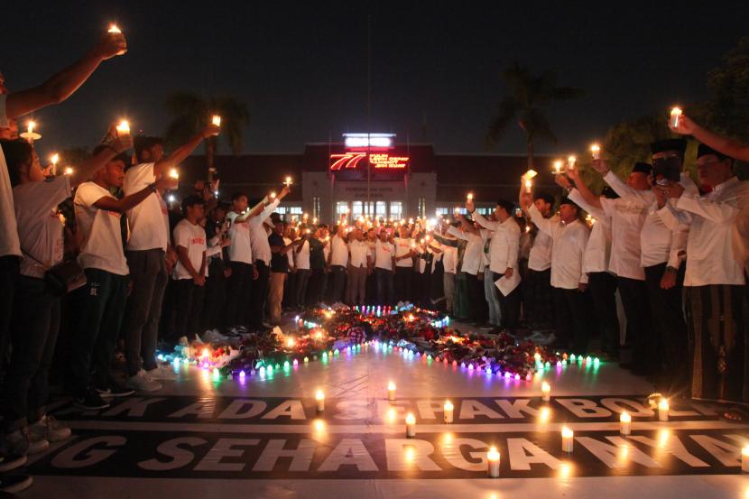 Warga membawa lilin saat doa bersama di Balai Kota Surabaya, Jawa Timur, Selasa (4/10/2022) malam. Doa bersama itu untuk para korban tragedi kerusuhan di Stadion Kanjuruhan, Malang. 