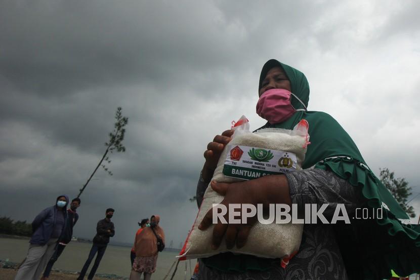 Warga membawa paket beras bantuan yang diperolehnya (ilustrasi)