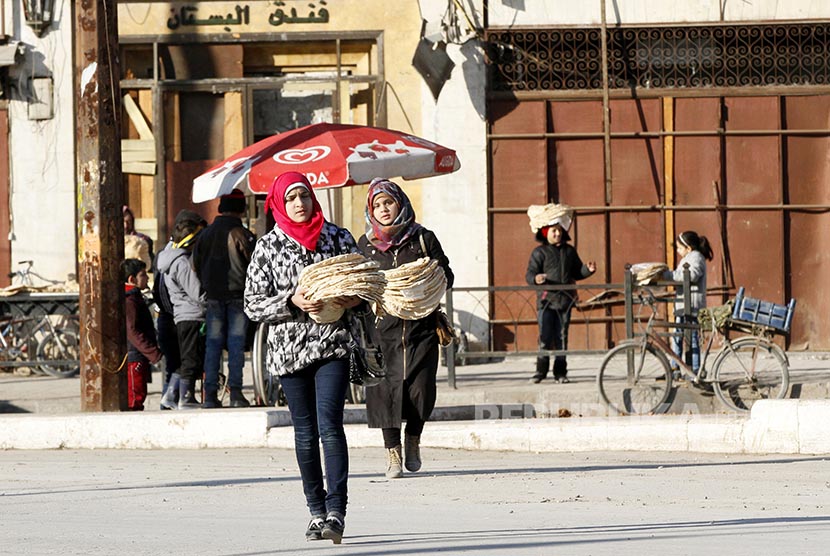 Warga membawa roti tradisional di bagian utara Kota Aleppo, Suriah. Pasukan pemerintah Suriah membuat kemajuan signifikan di provinsi Aleppo. Ilustrasi.