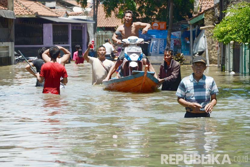 Warga membawa sepeda motornya ke luar dari lokasi banjir di daerah Cisirung, Dayeuhkolot, Kabupaten Bandung, Ahad (13/3).  (Republika/Edi Yusuf)