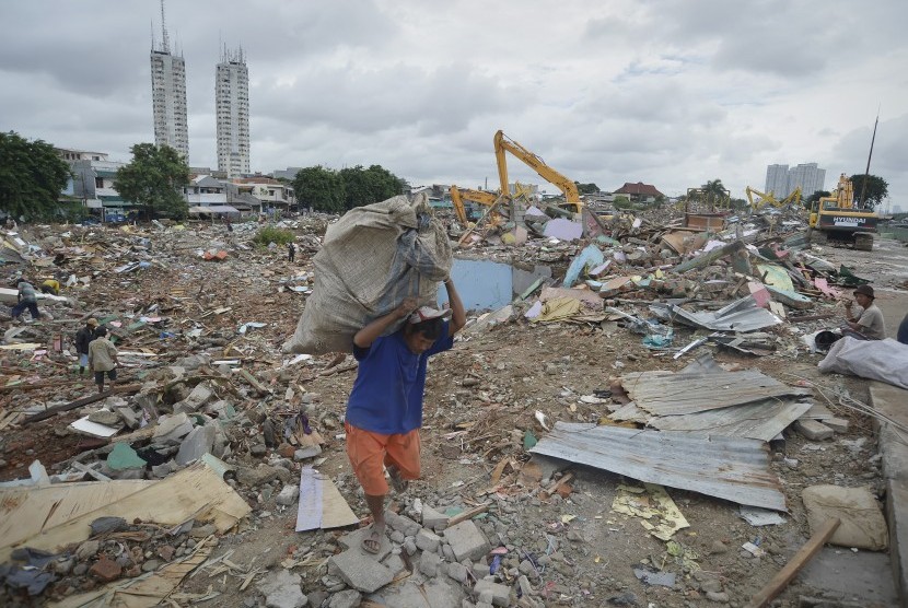 Warga membawa sisa-sisa besi di antara bangunan yang dirobohkan di kawasan Kalijodo, Jakarta, Selasa (1/3).
