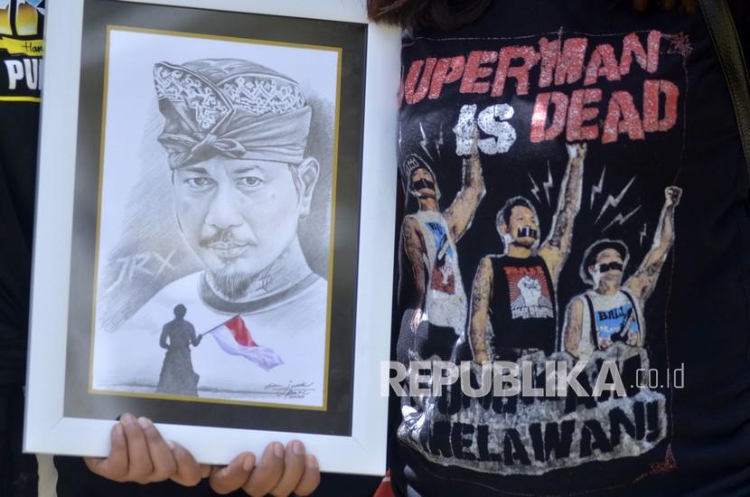Warga membawa sketsa wajah drummer Superman is Dead I Gede Ari Astina alias Jerinx sebagai bentuk dukungan saat Jerinx menjalani pemeriksaan di Polda Bali, Denpasar, Bali, Selasa (18/8). (ilustrasi)