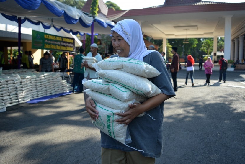 Warga membawa zakat fitrah berupa beras. 