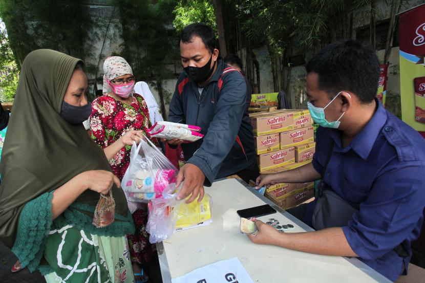 Warga membeli bahan pokok saat digelarnya pasar murah di Jalan Petukangan, Surabaya, Jawa Timur, selasa (15/3/2022). (Ilustrasi)