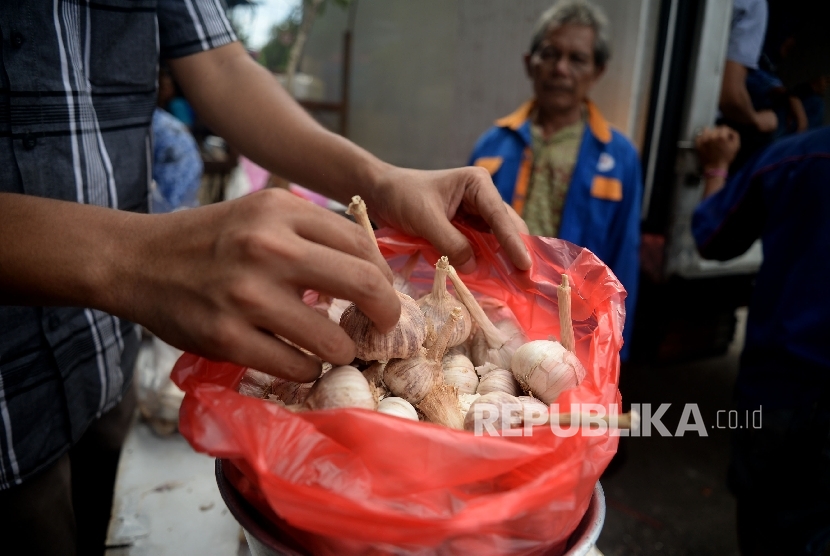  Warga membeli bawang putih saat dilaksanakananya operasi pasar komoditas bawang putih di Pasar Senen, Jakarta, Kamis (1/6). 